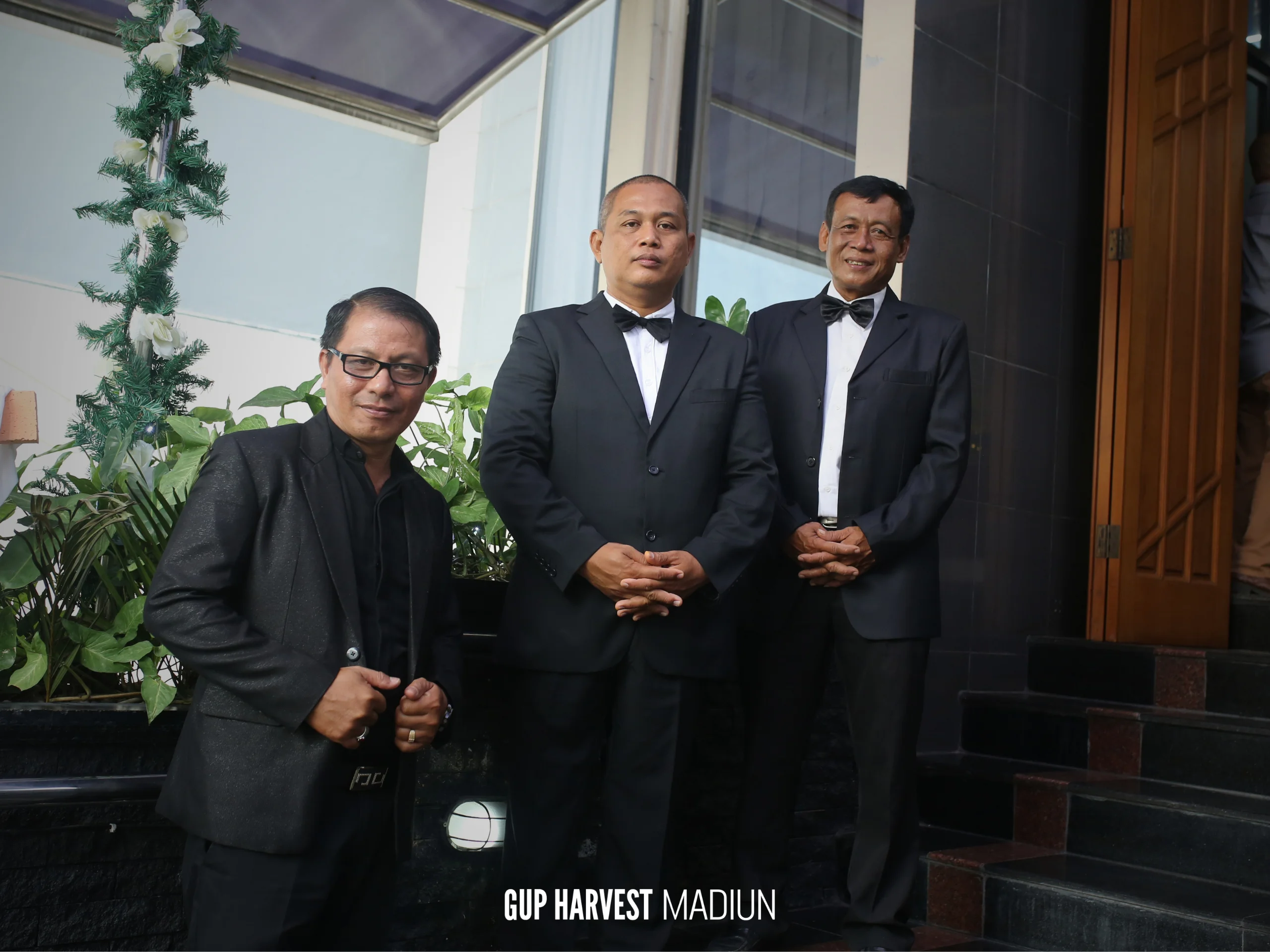 Dokumentasi panitia pria berpakaian formal di area depan gedung GUP Harvest Madiun.