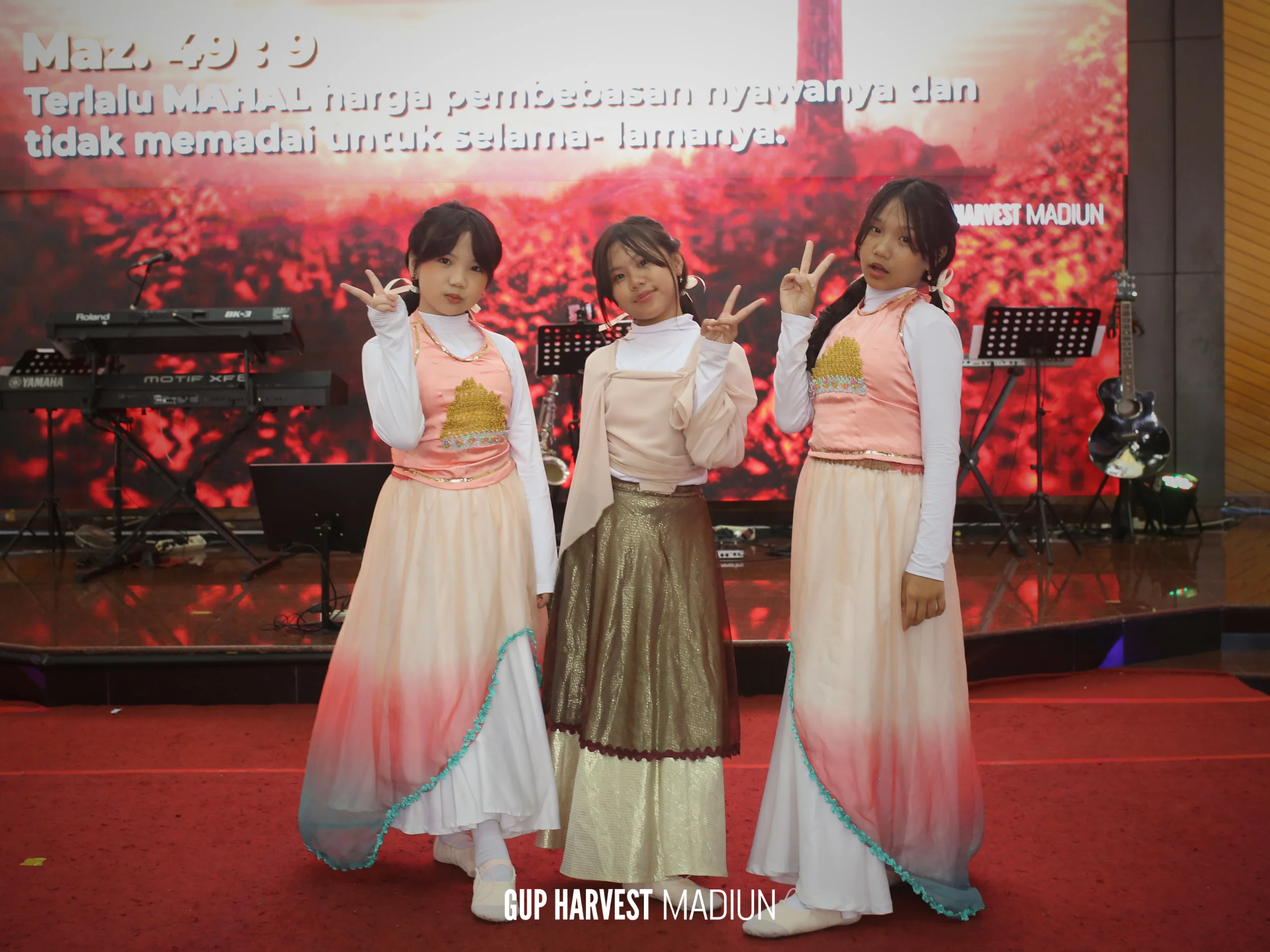 Tiga penari anak perempuan berpose ceria di atas panggung setelah melayani tarian dalam Ibadah Paskah.