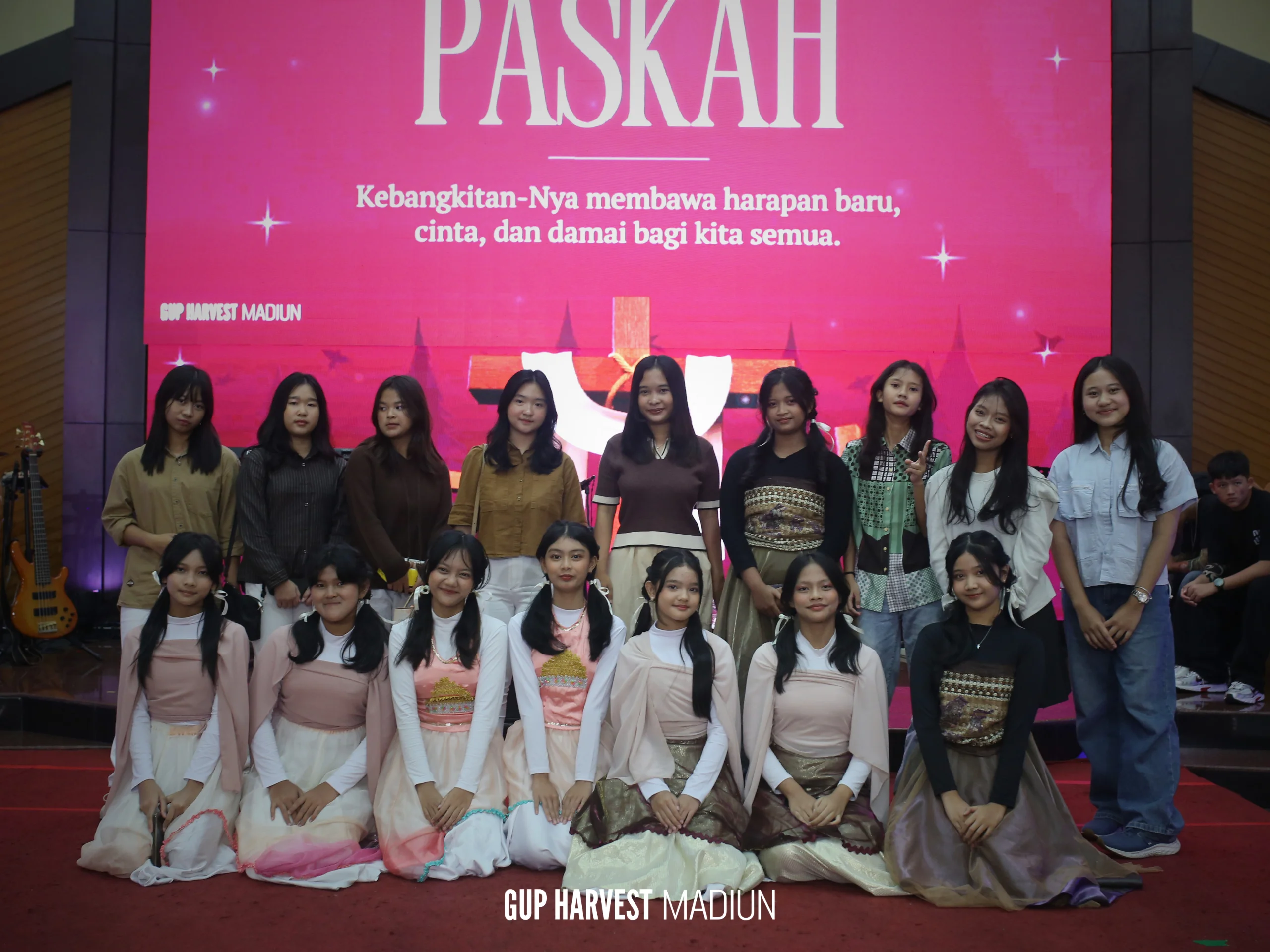 Foto bersama para remaja dan pemudi gereja di depan layar LED panggung perayaan Paskah GUP Harvest Madiun.