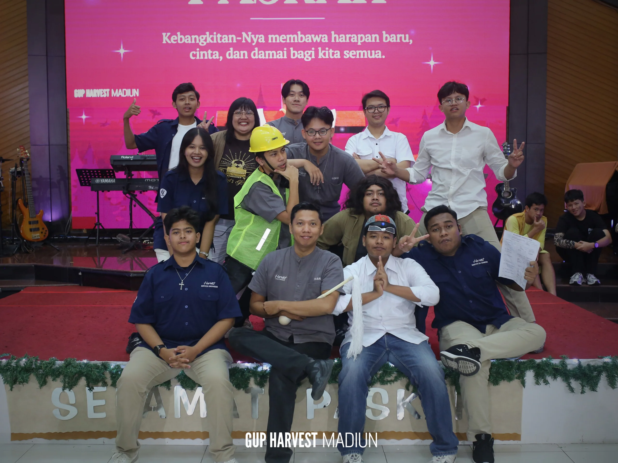Keseruan foto bersama tim pemuda dan para pemeran drama teatrikal Paskah GUP Harvest Madiun di atas panggung.