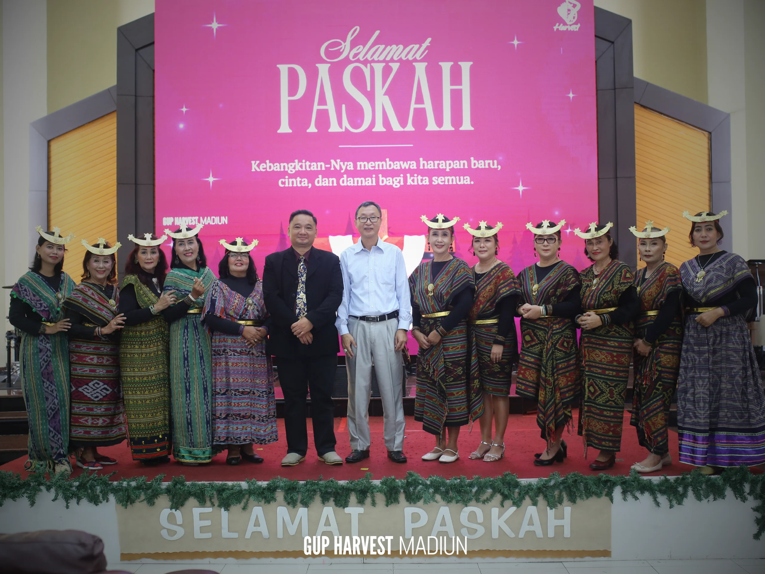 Potret resmi pendeta bersama tim penyambut tamu wanita yang mengenakan busana adat tenun nusantara pada perayaan Paskah.